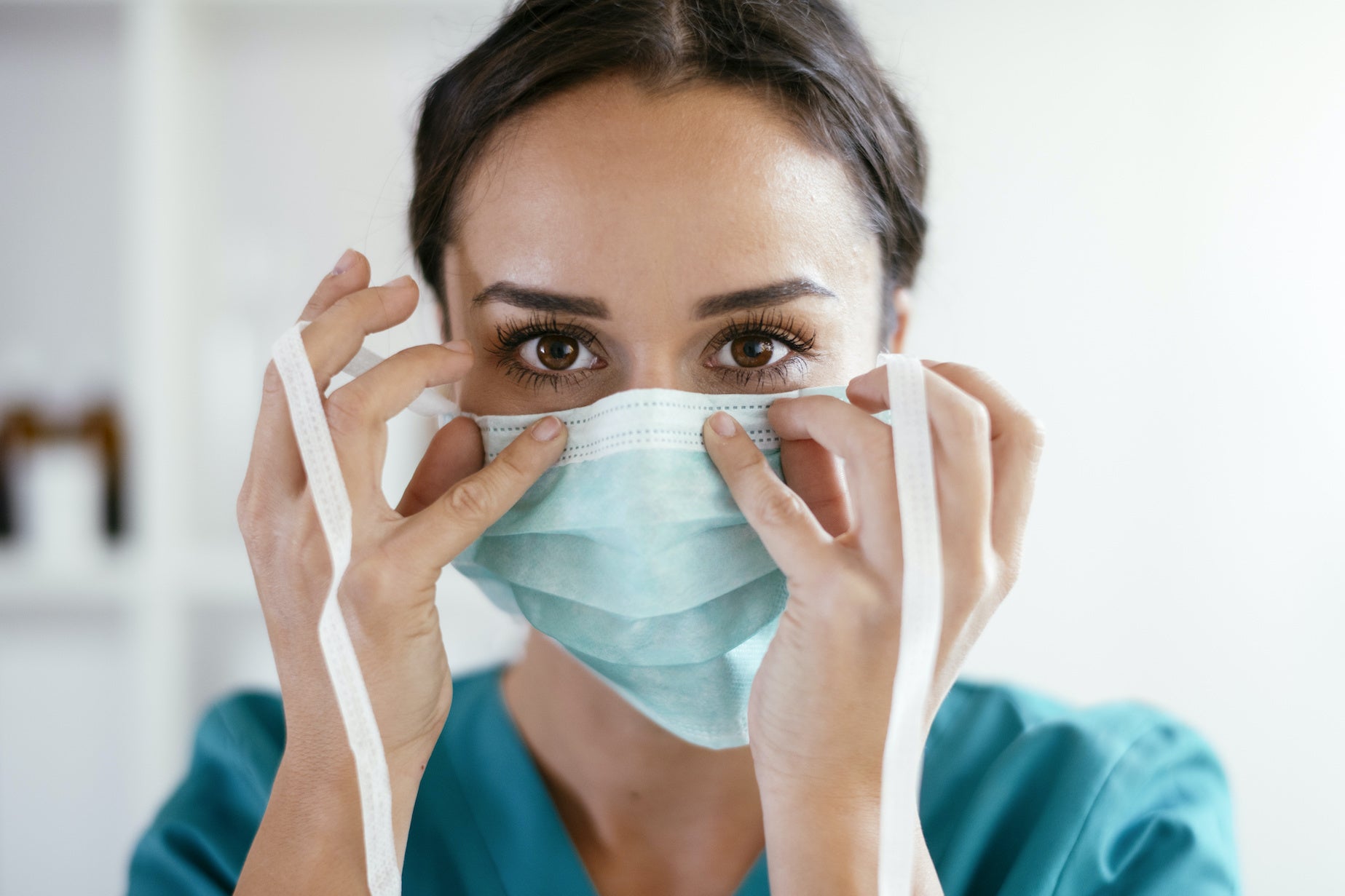Healthcare professional putting on protective mask